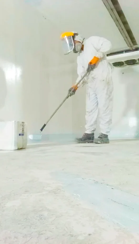 Operario reparando piso en fibra de vidrio de carrocería de furgón